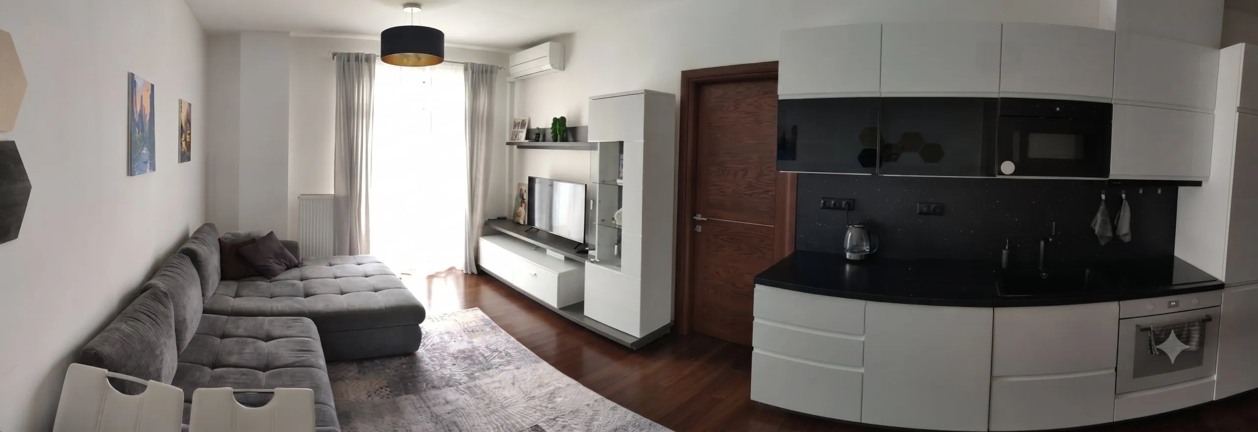 Panoramatický pohled do obývacího pokoje apartmánu s kuchyňským koutem